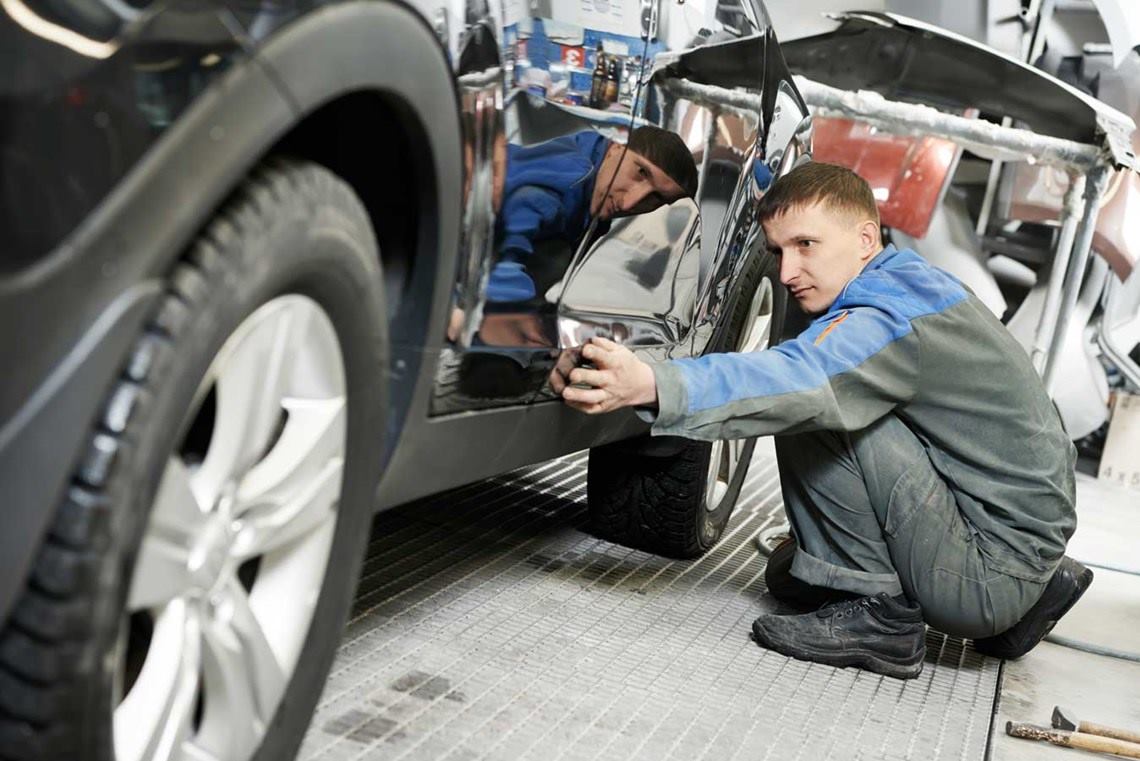 Mecánico revisa la carrocería de un automóvil