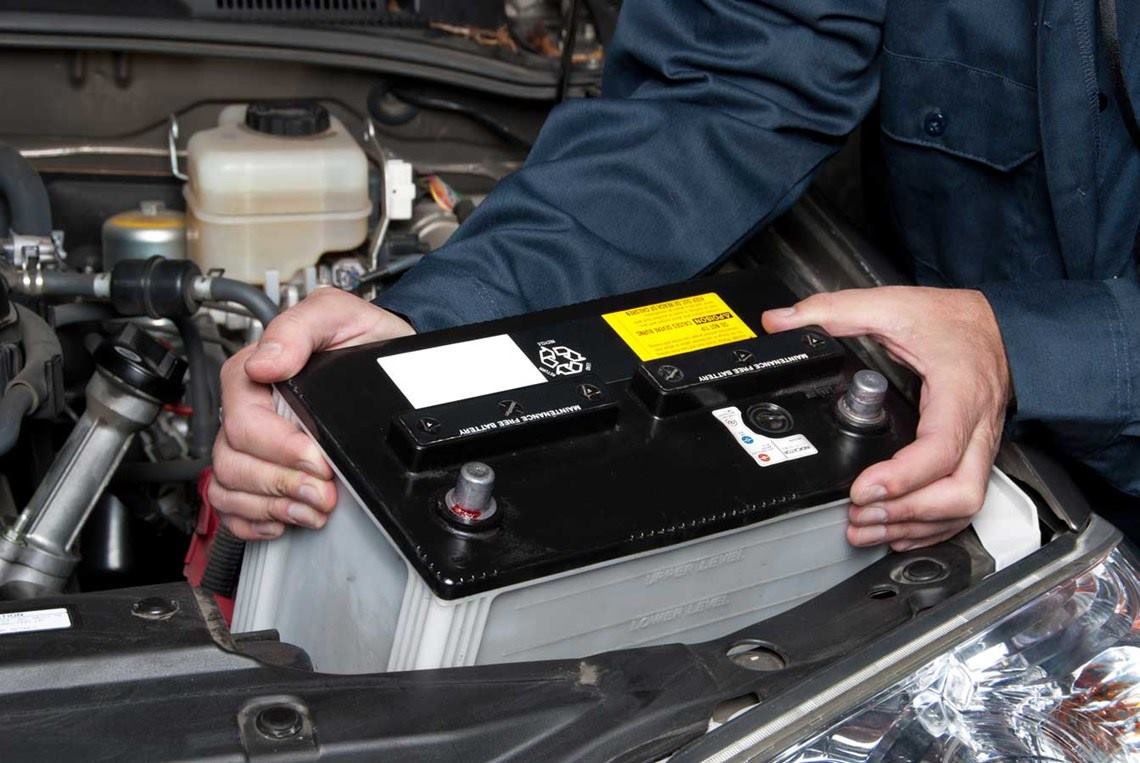 Mecánico saca la batería de un automóvil 